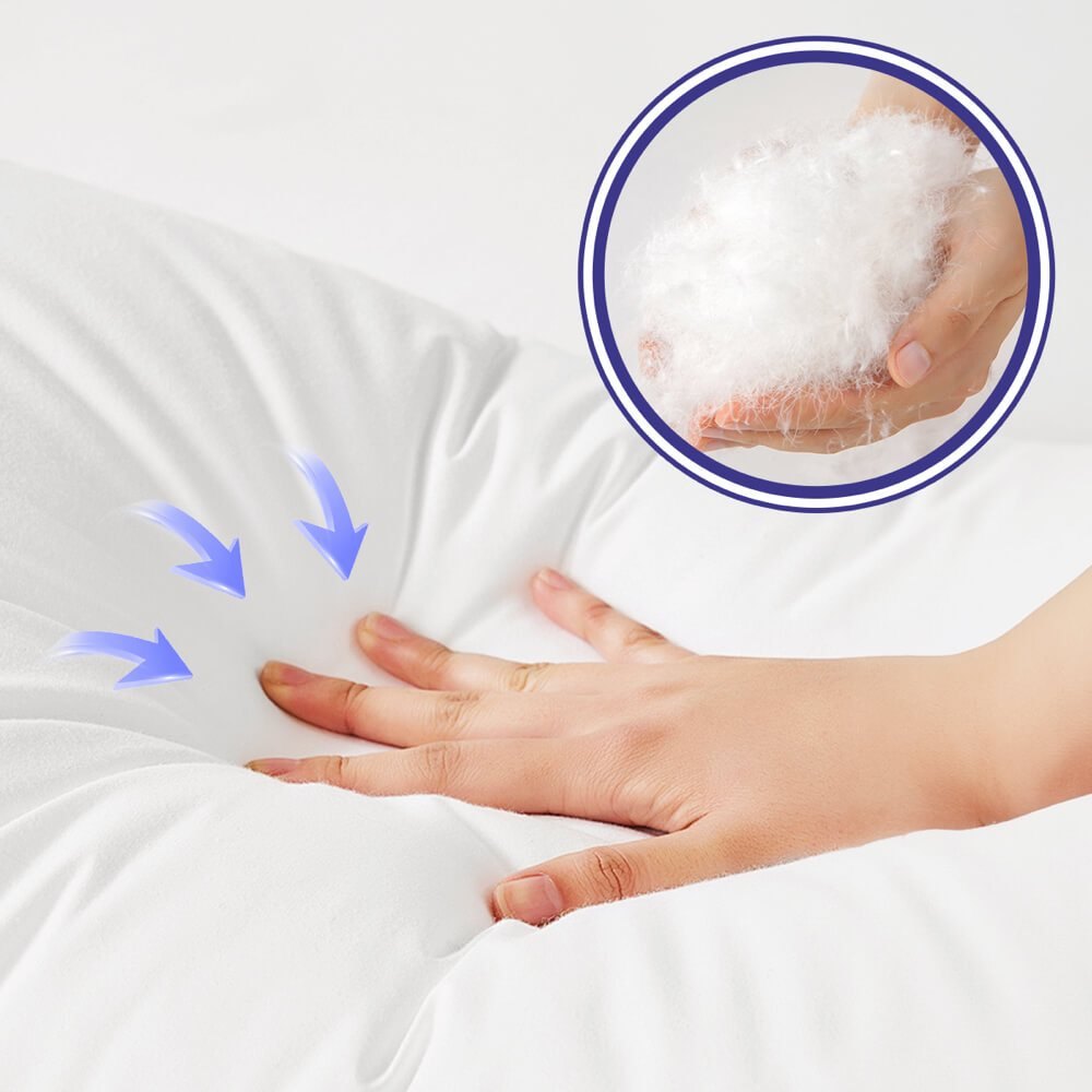 A hand pressing into a white pillow, with a close view of white fiber fill